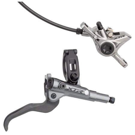 Shimano XTR M9100 disc brake with black caliper and rotor, mounted on a mountain bike wheel for precise stopping power.