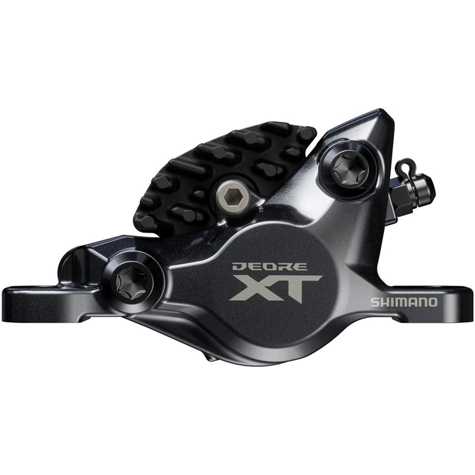 Shimano Deore XT BR-M8200 XC disc brake caliper mounted on mountain bike with hydraulic brake pads and mounting hardware.