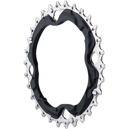 Shimano Deore M6000 10-speed chainring with black finish, designed for mountain bike cranksets, mounted on bicycle crank arm.