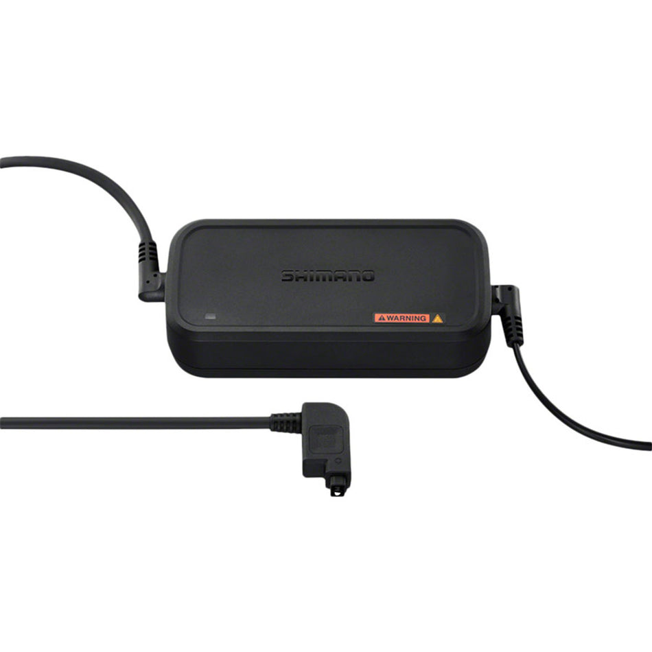 Shimano Steps eBike battery charger connected to a charging port, showing a compact black charger for e-bike batteries.