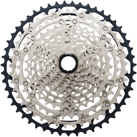 Shimano SLX CS-M7100 12-speed cassette with silver cogs, designed for mountain bikes, showing the gear teeth and branding.