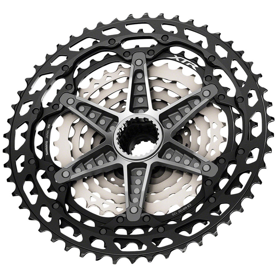Shimano XTR CS-M9100 12-speed cassette with silver cogs, showing gear teeth and spacing for mountain bike drivetrain.