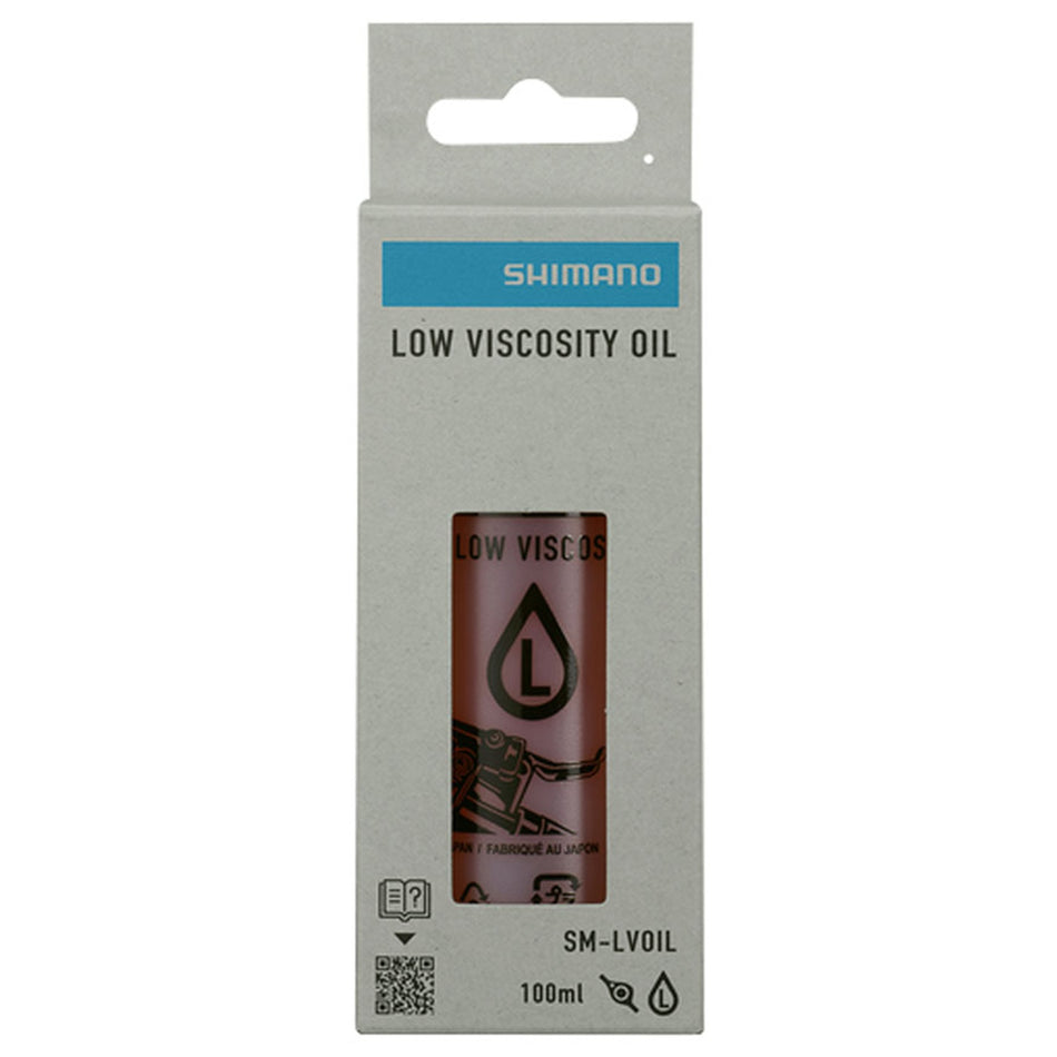 Shimano mineral oil disc brake fluid bottle with brake tools for bicycle maintenance and brake system care.