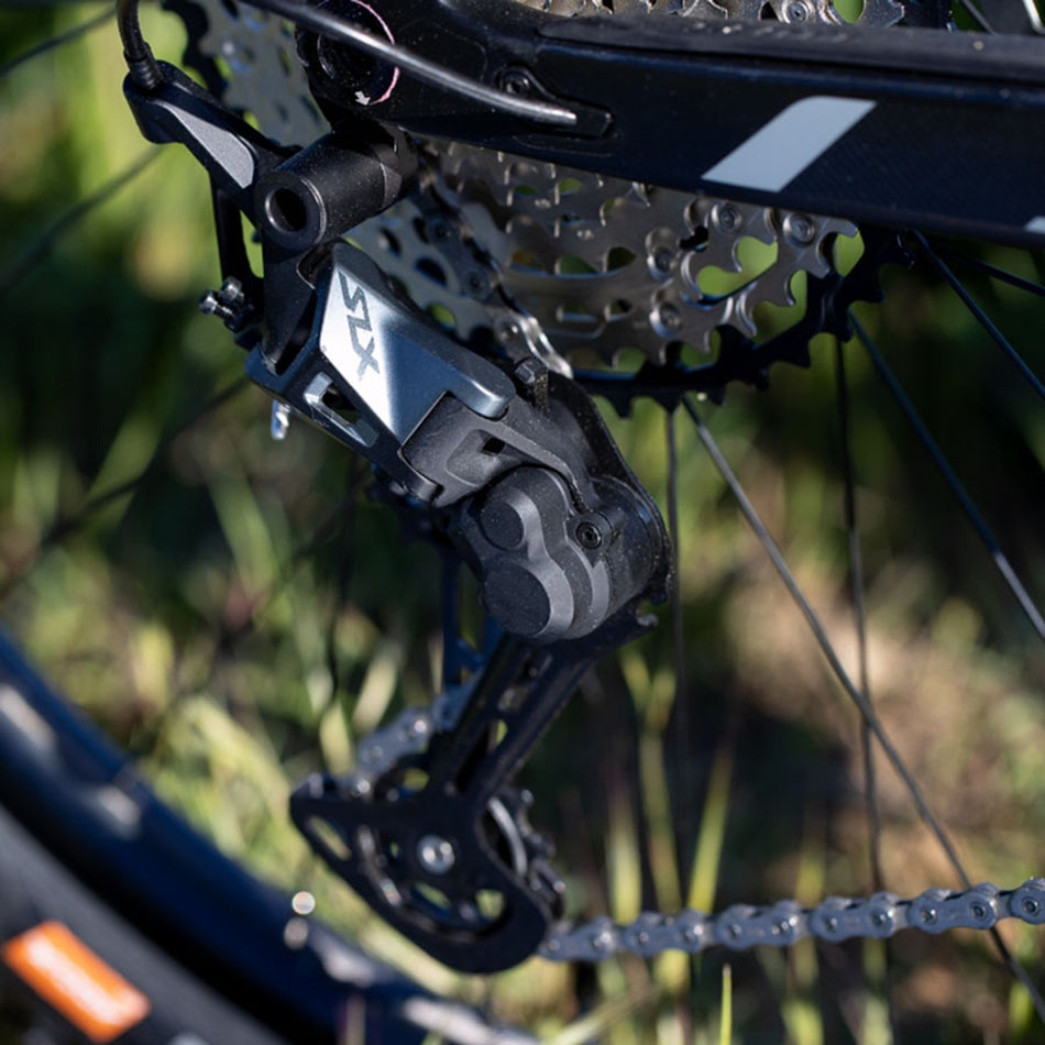 Shimano SLX RD-M7100-SGS rear derailleur with black finish and mounting hardware for mountain bike shifting.